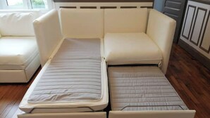 A convertible sofa-bed with a mattress that can be unfolded into a bed.