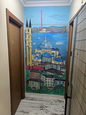 Stunning cityscape mural adorns the hallway, complemented by elegant doors and a beautifully finished floor.