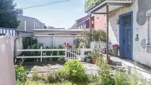 A courtyard with a white fence, potted plants, and a blue door. - Lovely apartment in Barth with WiFi (Barth)