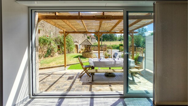 Een moderne kamer met een grote schuifglazen deur die uitkomt op een terras.