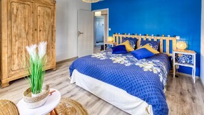 Een slaapkamer met een groot bed, een houten garderobe en een nachtkastje met lampen.