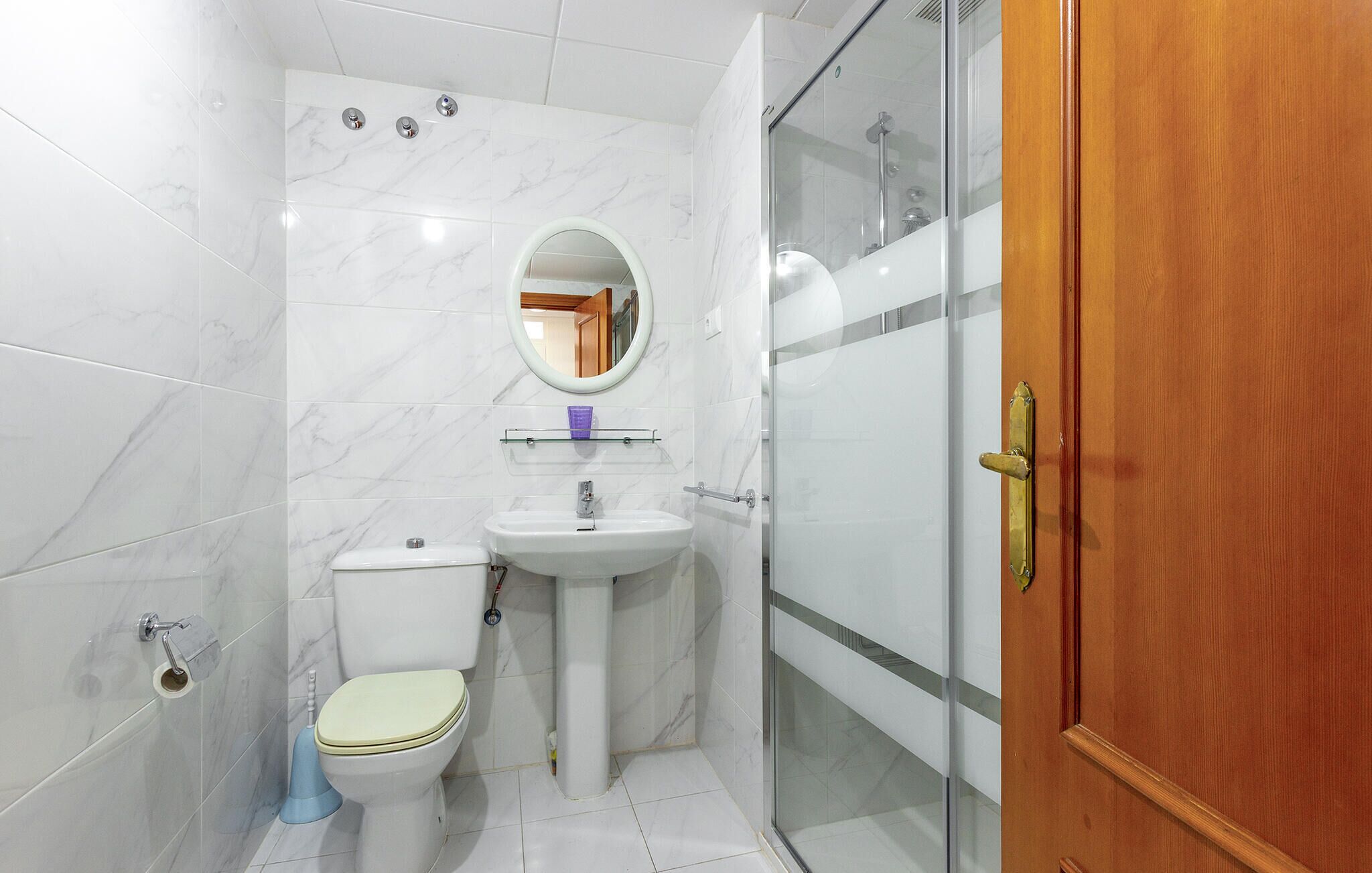A bathroom with a toilet, sink, and shower.