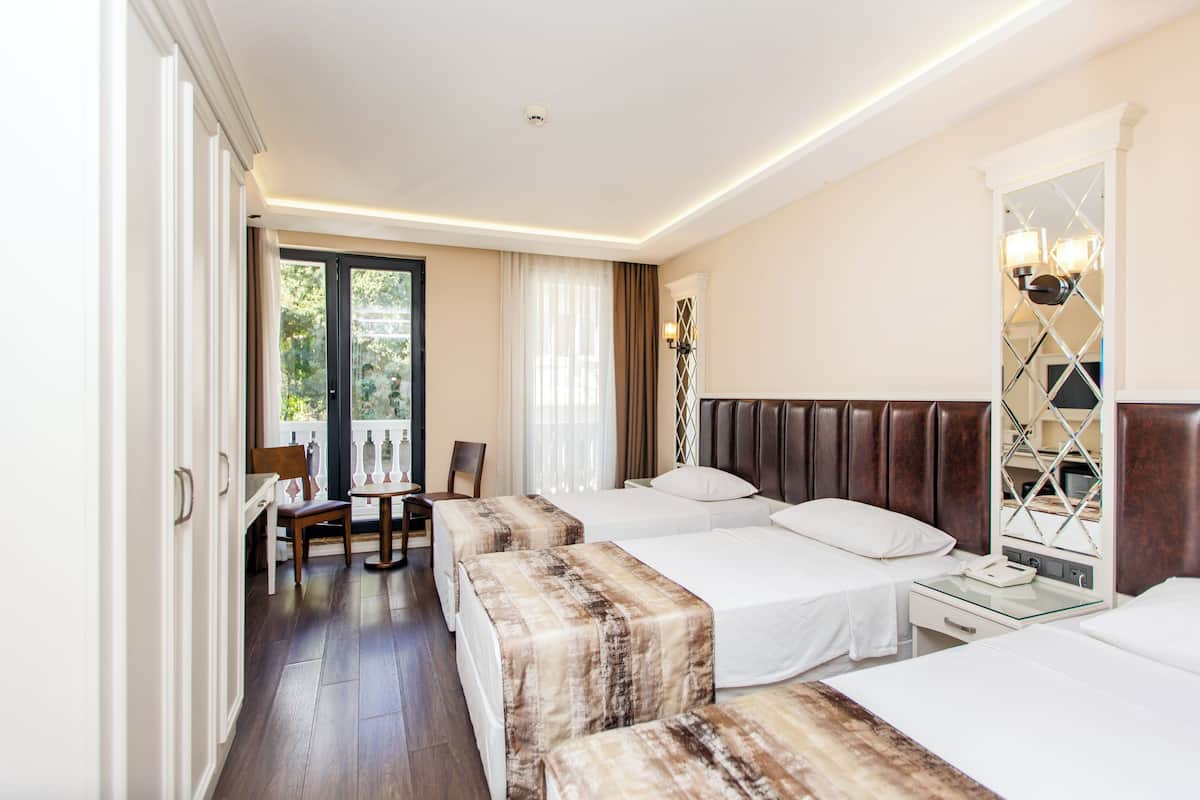 A hotel room with two beds, a desk, and a chair.