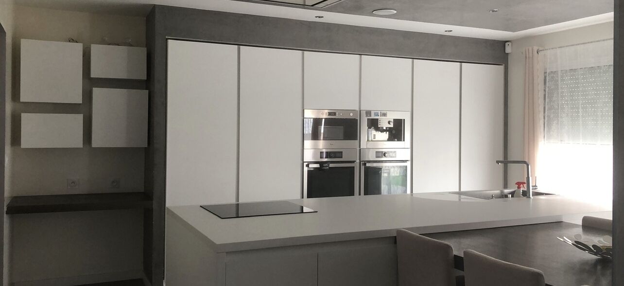 Una cocina moderna con electrodomésticos integrados, una isla grande y un comedor.