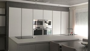 Una cocina moderna con electrodomésticos integrados, una isla grande y un comedor.