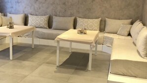 Una sala de estar moderna con un conjunto de sofá, dos mesas de centro blancas y una paleta de colores neutros.