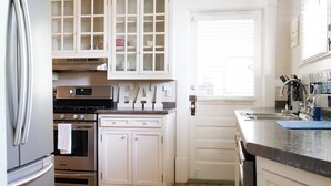 A kitchen with white cabinets, a stainless steel refrigerator, an oven, and a ceiling fan. - Stylish Family 3BR Stay | Pets Allowed (Montgomery)
