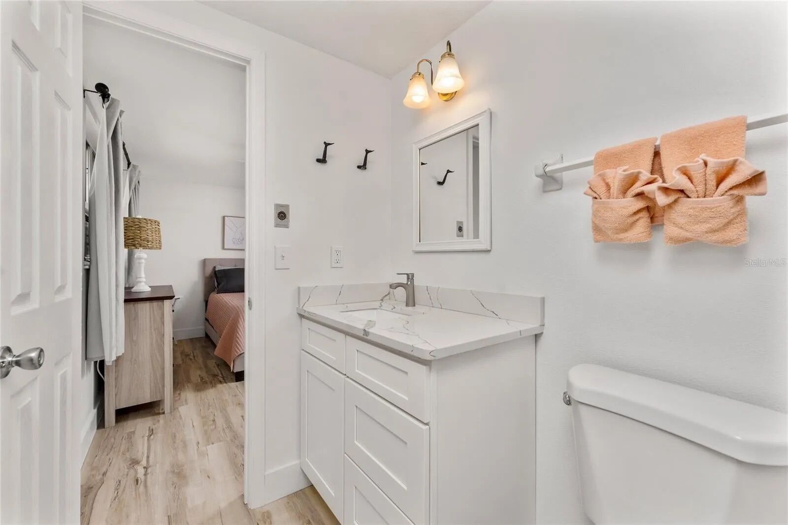 Une salle de bain moderne avec un meuble-lavabo blanc, des toilettes et un espace douche.