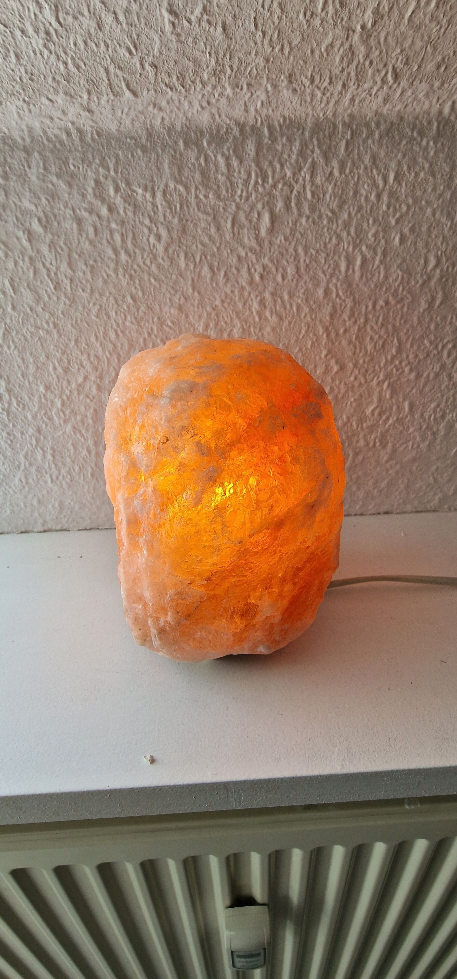 A textured wall and a rock-like object on a flat surface.