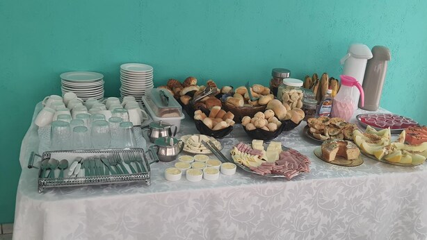 A buffet table with various food items and utensils. -  Pousada Barão Real (Sao Lourenco)