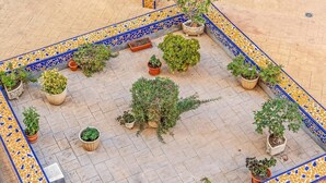 Un patio con piso de baldosas y diversos maceteros dispuestos en un diseño.