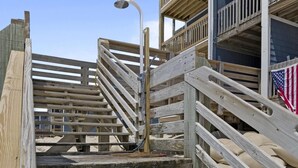 Un escalier en bois menant à un immeuble doté de balcons.