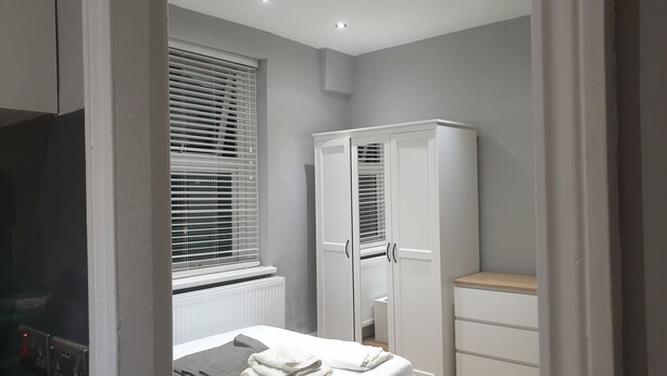 A bedroom with a bed, a wardrobe, and a radiator. - Barnet Luxury Apartment can sleep 4 people just few mins away from Station (Barnet)