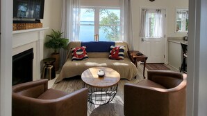 A spacious living room with a large window, a fireplace, and a cozy seating area.