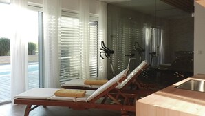 Een moderne kamer met een houten plafond, een douchecabine van glas en een houten vloer.