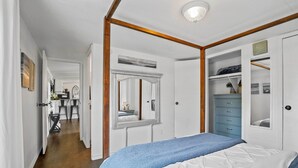 A bedroom with a large bed, a wardrobe, and a mirror. - Near Water: Lake Dallas Home w/ Furnished Patio! (Lake Dallas)