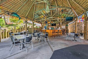 Enjoy al fresco dining in a charming outdoor setting with tables and chairs amidst lush surroundings.