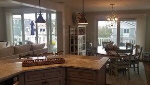 A kitchen with a dining area, a chandelier, and a view of the outside. - 159 26th Street - Spacious home in the heart of Avalon, two blocks to beach. (Avalon)