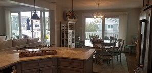 A kitchen with a dining area, a chandelier, and a view of the outside. - 159 26th Street - Spacious home in the heart of Avalon, two blocks to beach. (Avalon)