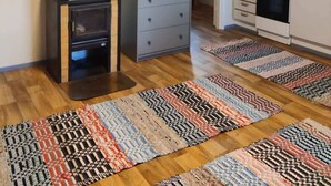 Une cuisine moderne dotée d’une cuisinière intégrée, d’un petit placard et d’un tapis à motifs sur le sol.