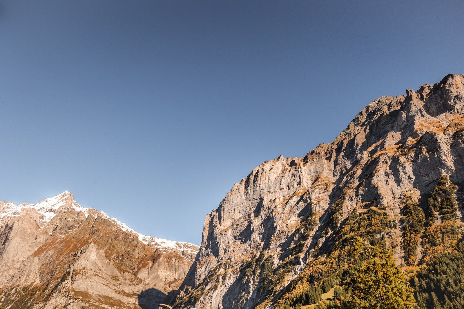 A mountainous landscape with rocky cliffs and sparse vegetation.