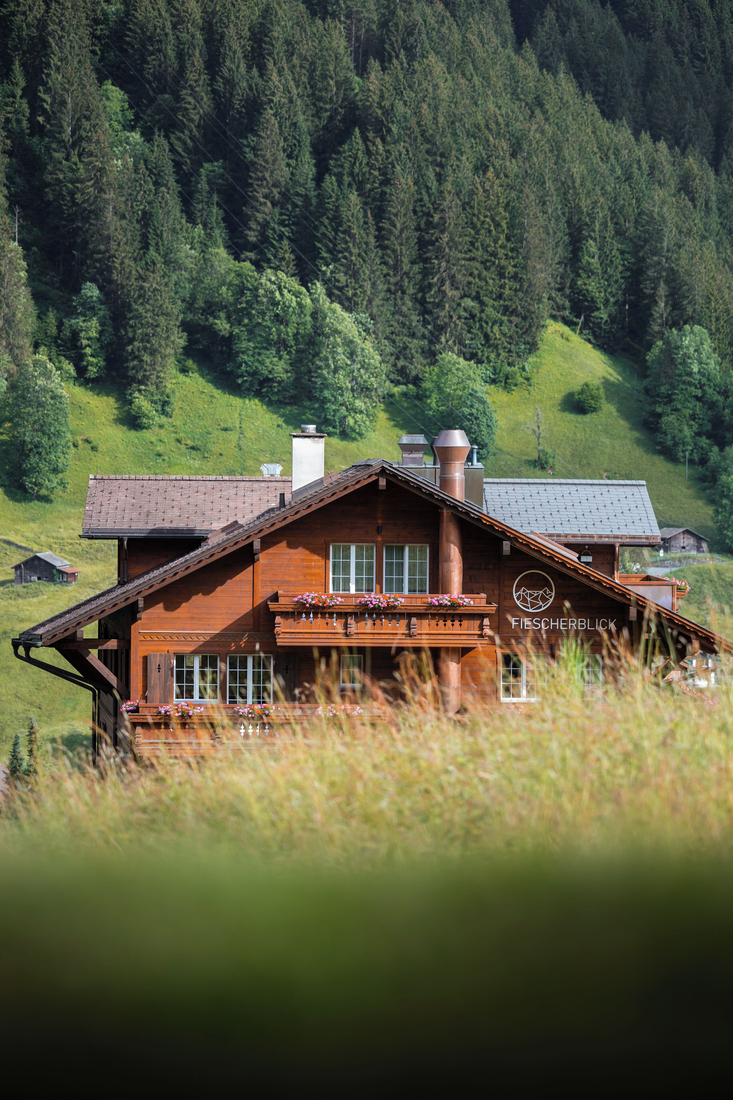 Un chalet en bois doté d’un balcon, d’une cheminée et d’un logo sur le côté.