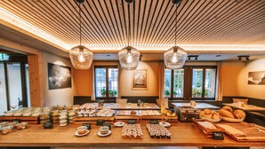 A breakfast buffet with various food items and a wooden ceiling. - Hotel Fiescherblick (Grindelwald)