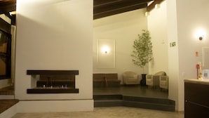 A reception area with a reception desk, a potted plant, and a staircase leading to another level.