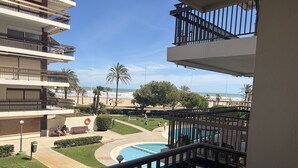 Een hotel met meerdere verdiepingen, balkons, een zwembad en uitzicht op het strand.