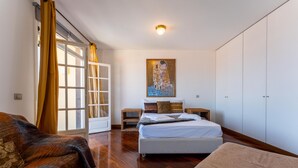 Ein Schlafzimmer mit Bett, Nachttischen, einem Gemälde und einem Kleiderschrank.
