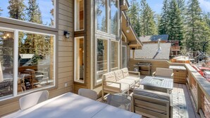 A modern outdoor patio with a sofa, dining table, and chairs. - Lake Views, Hot Tub, Walk to Beach! (Carnelian Bay)
