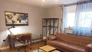 Ein Wohnzimmer mit einem Holztisch, Ledersessel, braunem Sofa und einem kleinen Couchtisch.