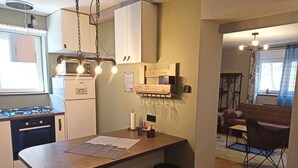 Eine kompakte Küche mit einer zentralen Kochinsel, Barhocker und einer Kaffeestation.