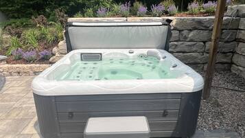 A spa hot tub with a built-in seat and a step for easy access.