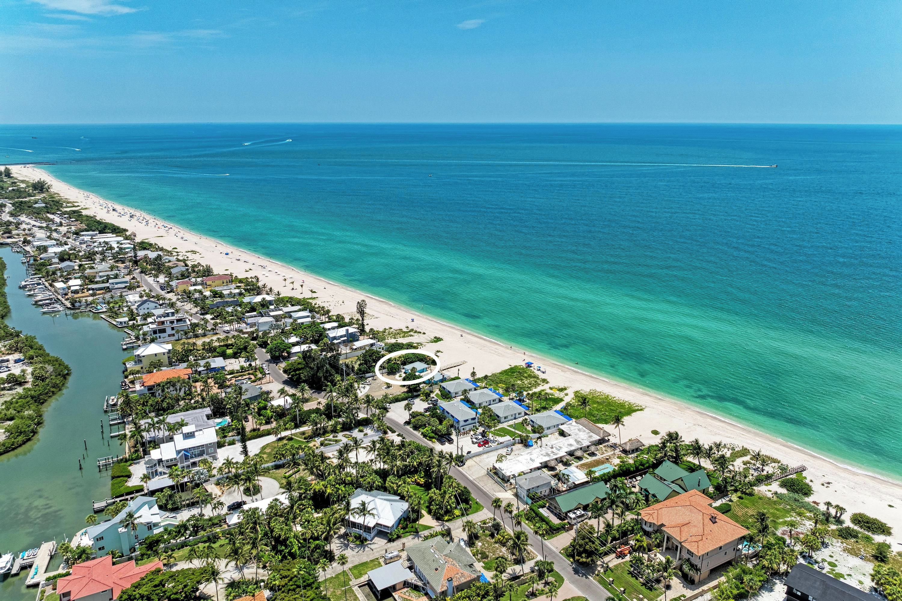 A coastal residential area with houses, a beach, and a marina.