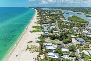 A coastal area with a beach, houses, and a waterway. - Casey Key Beachfront Escape: Charming 1BR Cottage (Nokomis)