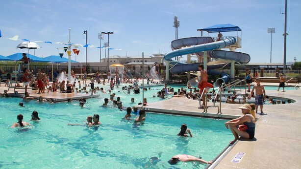 A public swimming pool with multiple water slides and a large crowd of people. - Loft Escape Artistic (Surprise)