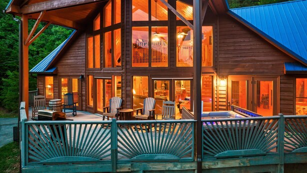 A wooden cabin with a large deck, multiple windows, and a hot tub. - Private cabin with stunning views near Pigeon Forge (Sevierville)