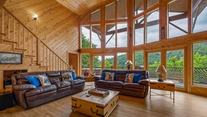 A spacious living room with wooden floors, large windows, and a staircase. - Private cabin with stunning views near Pigeon Forge (Sevierville)