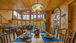 A wooden dining room with a large table set for a meal, surrounded by rustic chairs. - Private cabin with stunning views near Pigeon Forge (Sevierville)