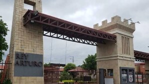 Una entrada con puerta metálica y un letrero que dice 'REY ARTURO'.