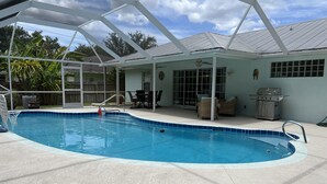 A covered swimming pool with a patio area, including a grill and outdoor furniture. - 3/2 with Heated Pool - Tranquil Tropical Escape
(Sebastian)