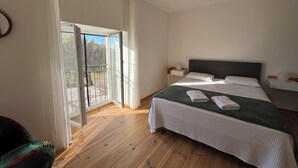 A bedroom with a large bed, a nightstand, a chair, and a sliding glass door leading to an outdoor area. - Bed and breakfast / gîte with SPA (Massages on reservation) (Domessargues)