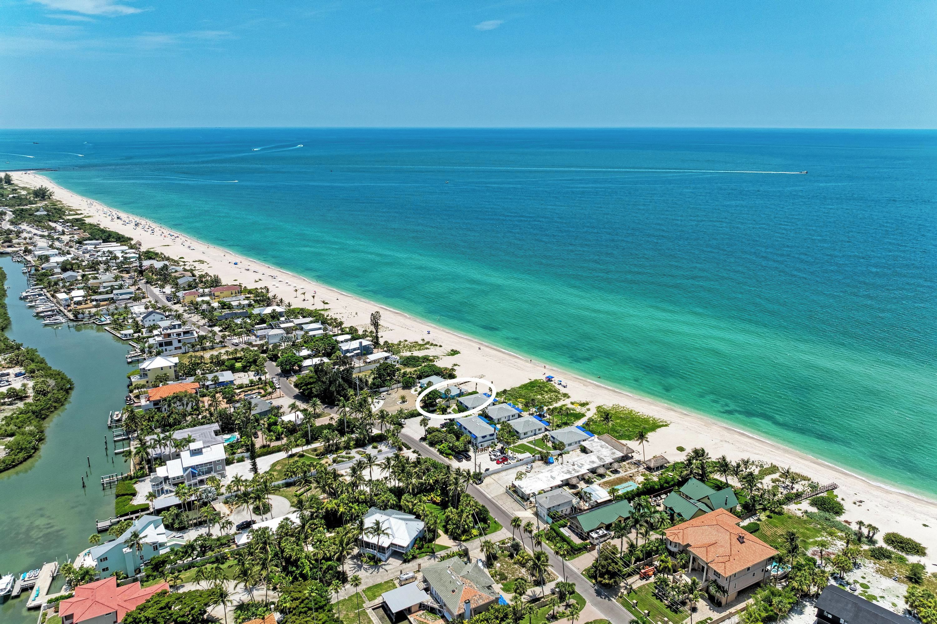 A coastal residential area with houses, a beach, and a marina.