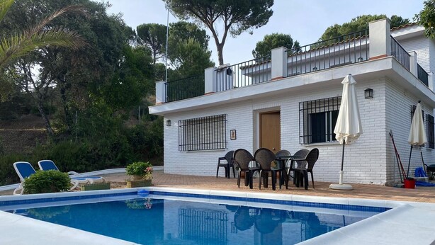 Une maison moderne à deux étages, dotée d’une piscine, d’un espace salon extérieur et d’un jardin.