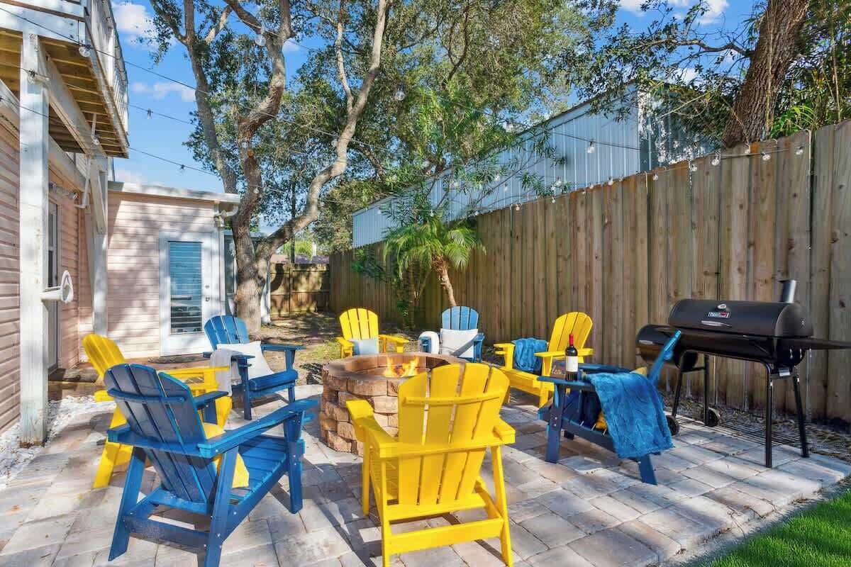 Un jardin avec un foyer, du mobilier d’extérieur et un barbecue.