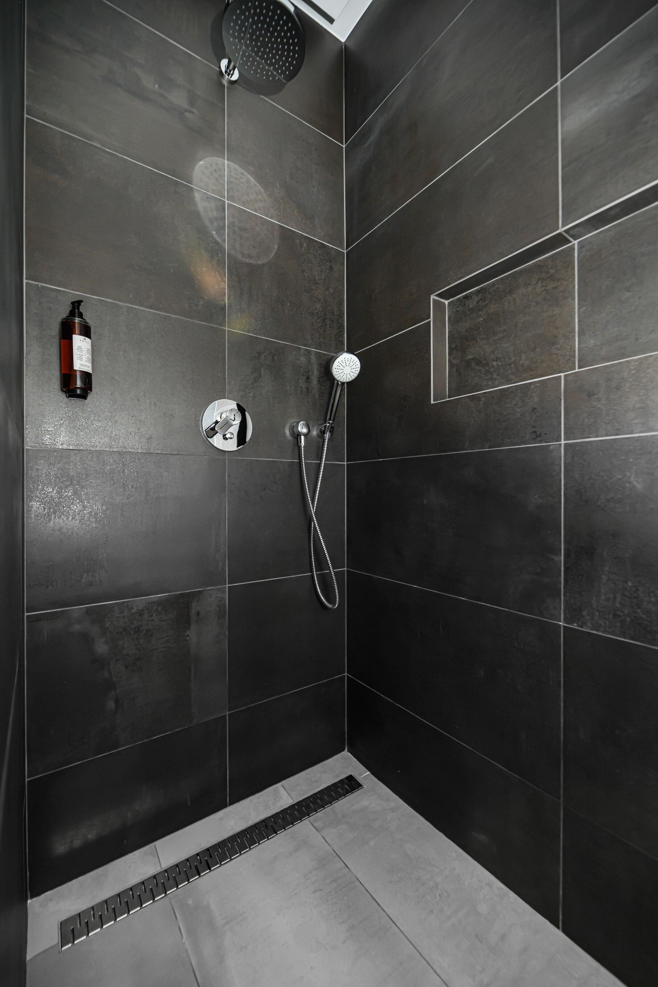 Ducha moderna con cabezal de ducha de mano y grifo empotrado.