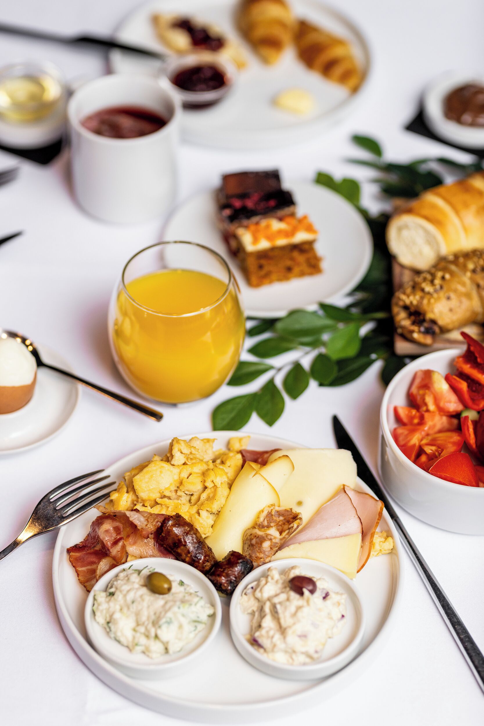 A breakfast spread with various dishes and drinks on a table.