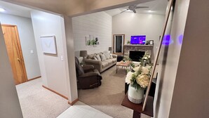A living room with a sofa, armchairs, a fireplace, a television, and a ceiling fan. - Tranquil waterfront cottage in Central Lake (Central Lake)
