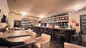 A bar area with multiple seating options, a bartender, and shelves stocked with bottles. - Tranquil waterfront cottage in Central Lake (Central Lake)